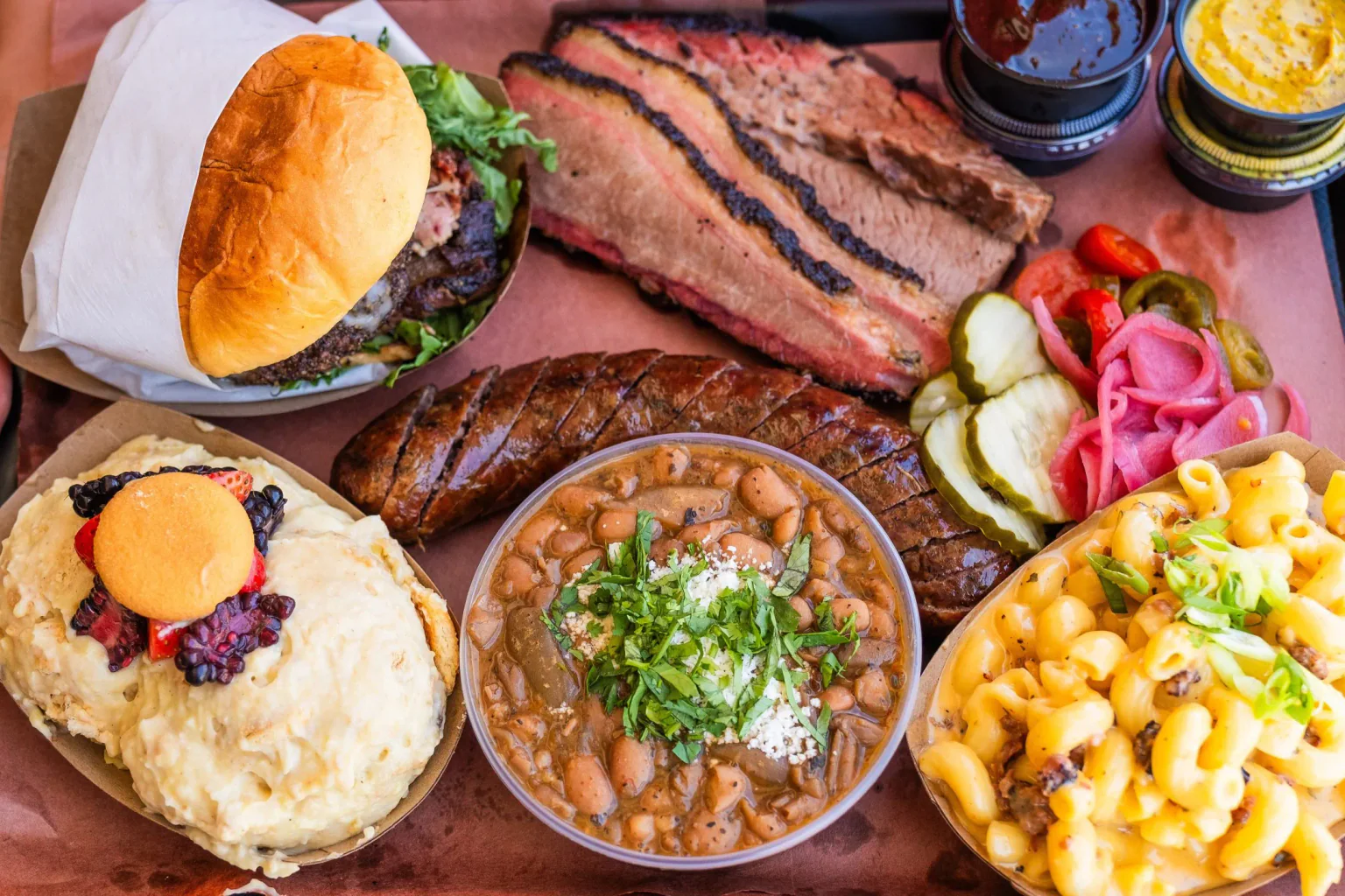 A butcher-paper spread of smoked brisket, ribs, sausage, and sides from Heritage Barbecue.
